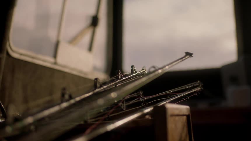 Fishing rods sit against a wood crate on a boat