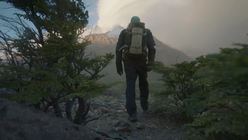 A man is hiking on a very windy day