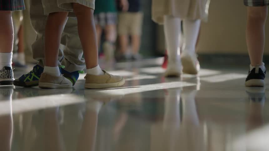 Group of children standing and walking in a hall
