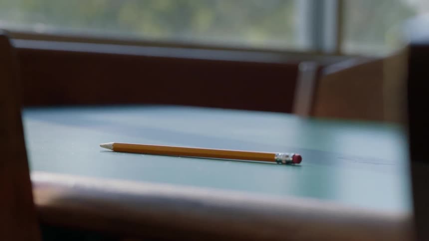 A pencil is sitting on a wooden table