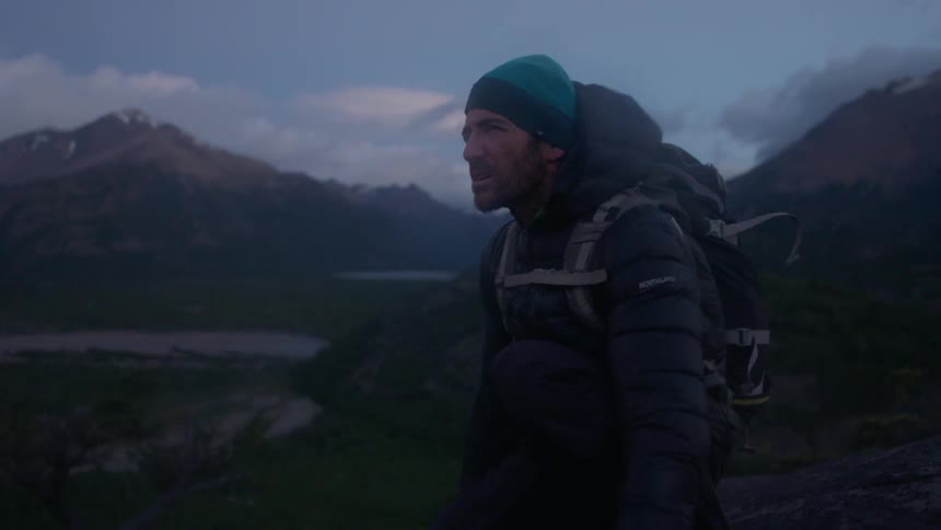 A hiker stands in the mountains
