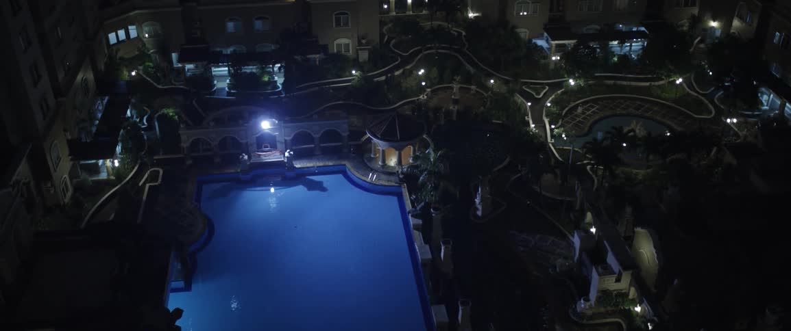 A large swimming pool is shown outside at night