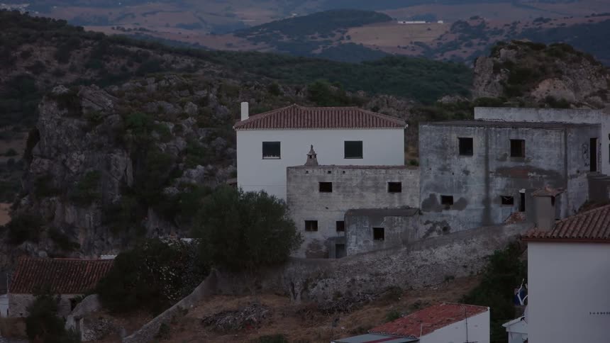 Buildings are shown in a hilly area