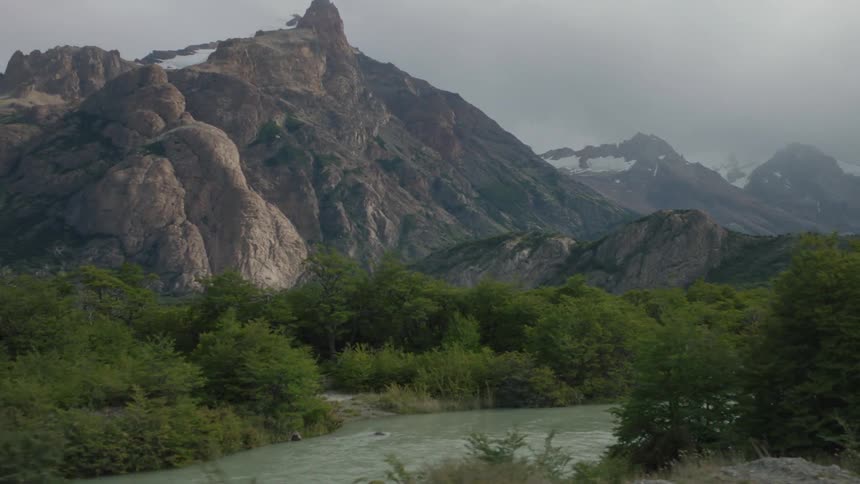 A river runs on the hill by a mountain