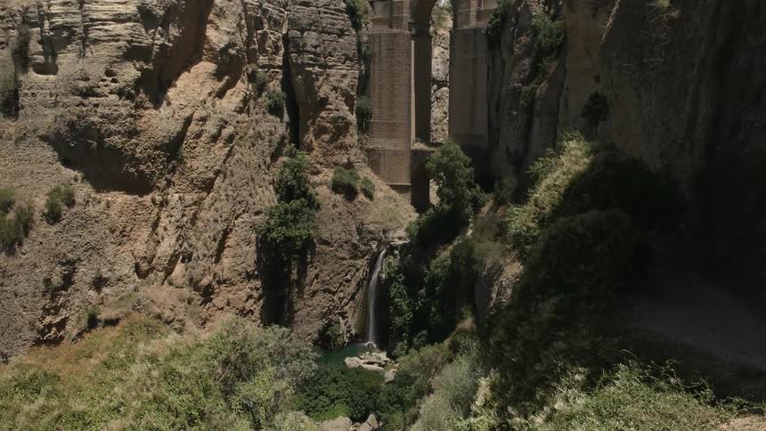 A castle with a bridge is built into the side of a mountain
