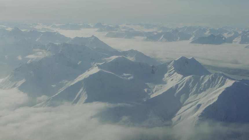 Aerial view of a large mountain range covered in snow