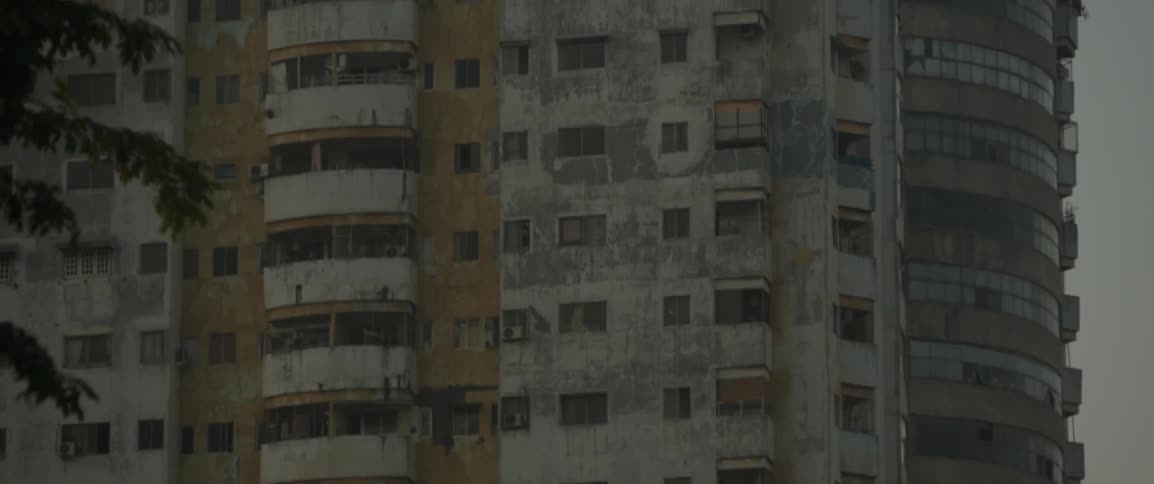 The building ahead is rundown and grey