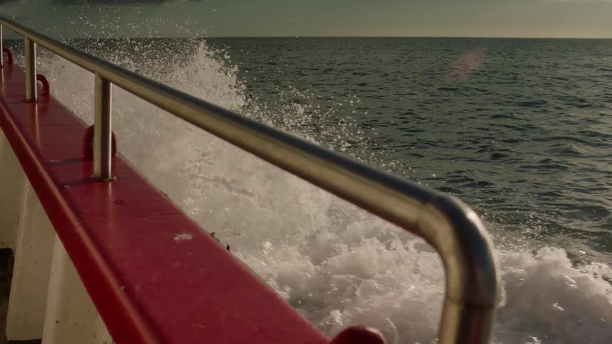 Waves crash against the moving boat