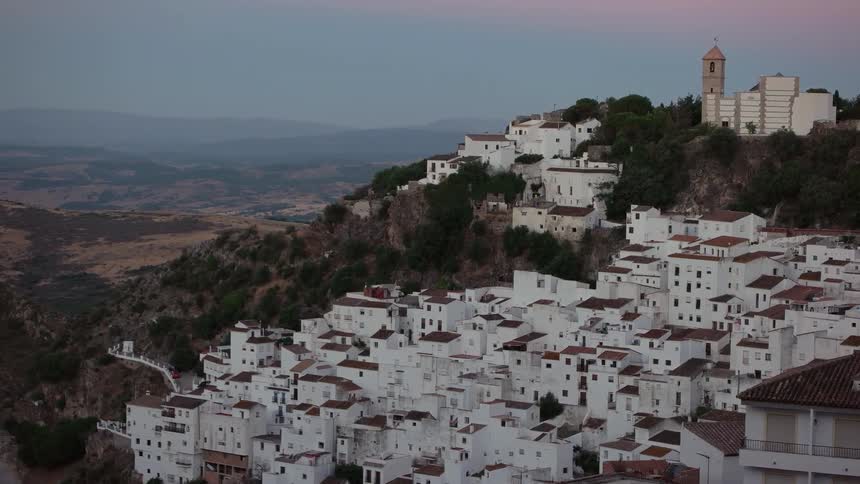 Many white houses sit on the top of a hill