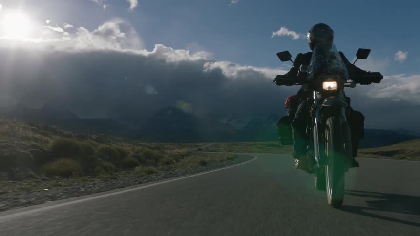 Motorcycle travels down the highway under a blue sky