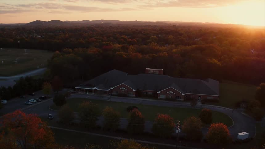 Looking down at a building with a circular drive at sunset