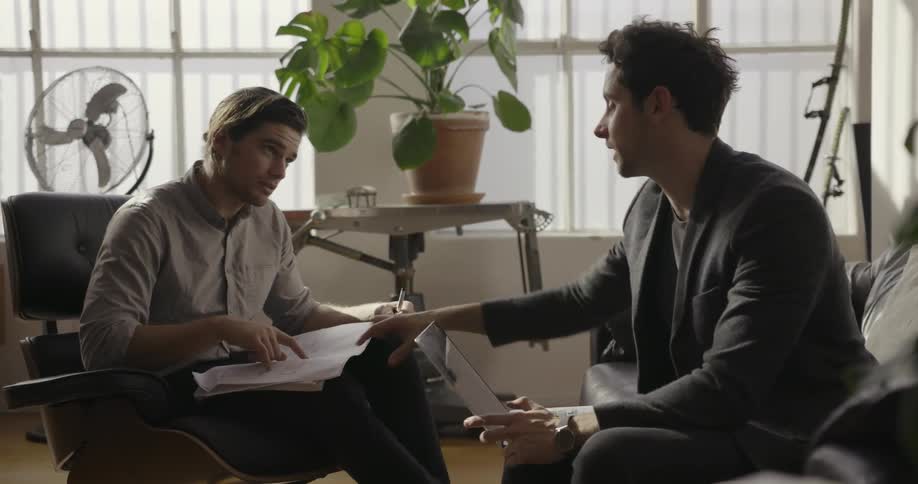 Male coworkers have a discussion in an office