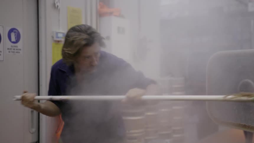 Someone is scraping hot food out of a machine