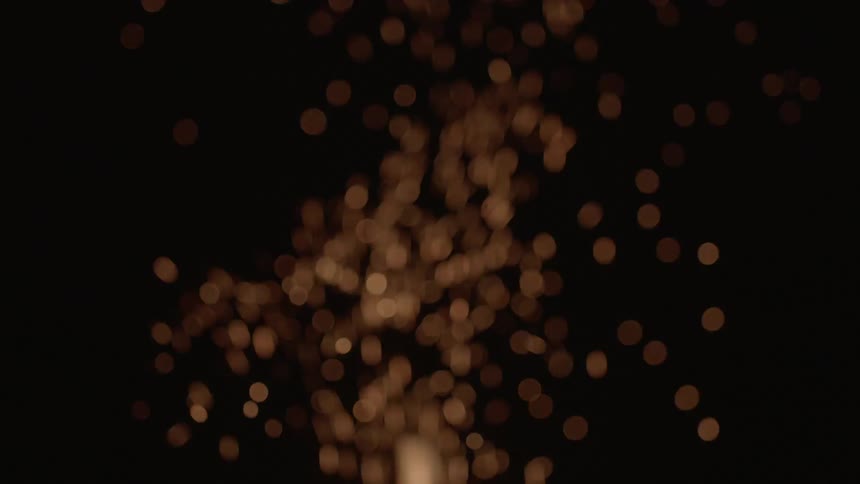 Sparks and embers from a fire rise into to darkness