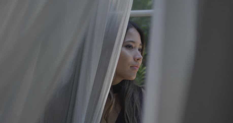 A woman is sitting on the ledge of a window