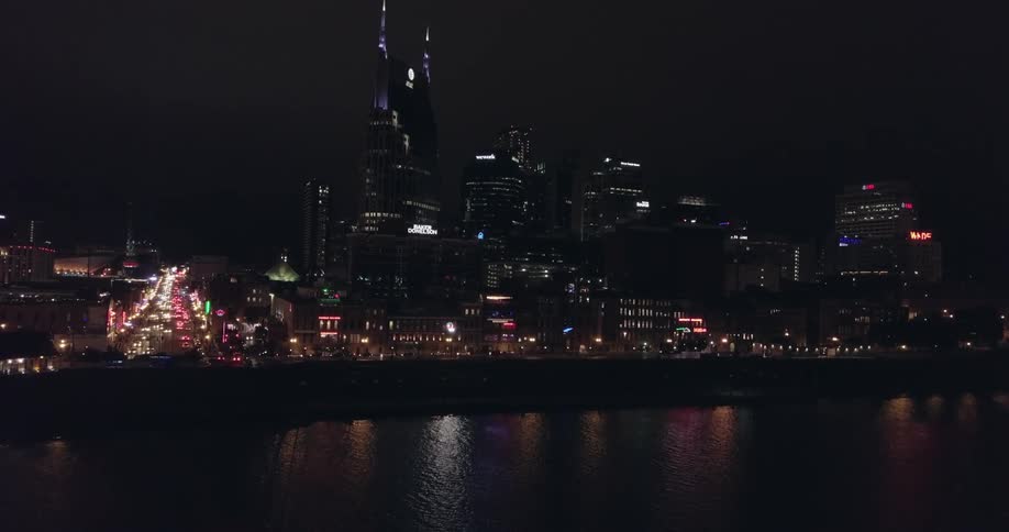 A large city is lit up next to the water at night