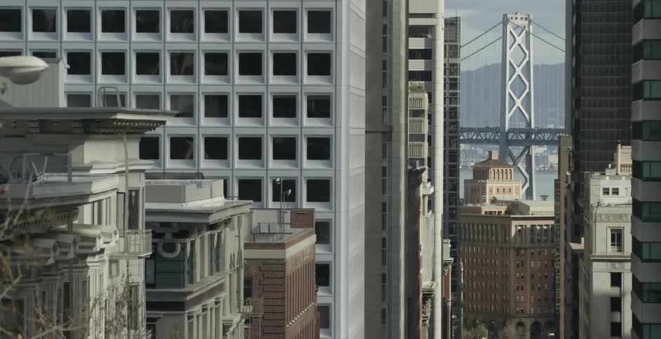 Large buildings in the downtown of a city with a bridge in the background