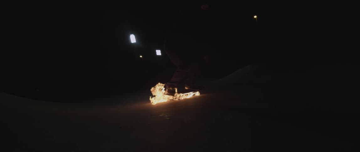 Someone is riding a skateboard while it's on fire