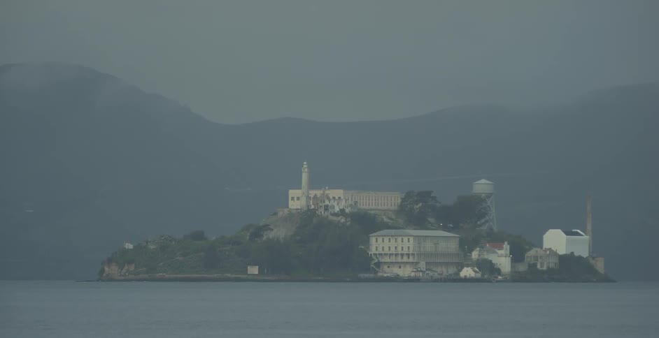 The lighthouse blinks from alcatraz in the mist
