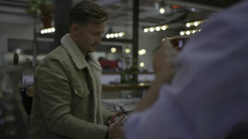 Man smiles and talks to a man working at a business