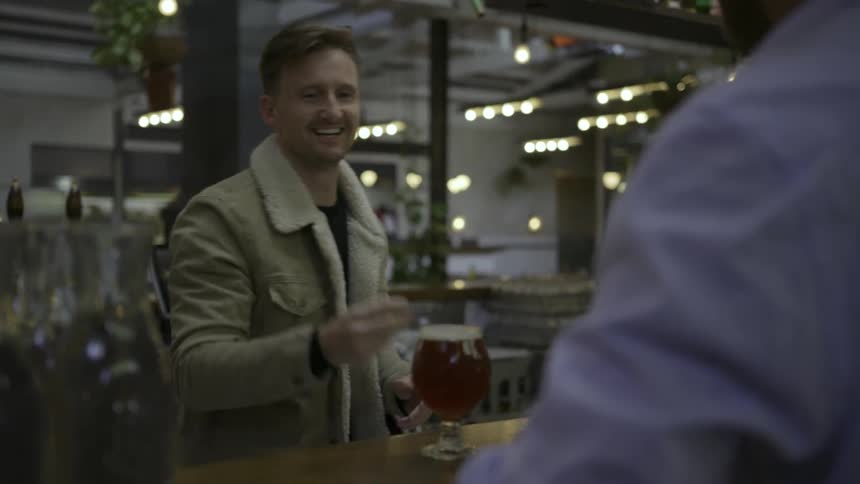 A man is serving a customer a beer