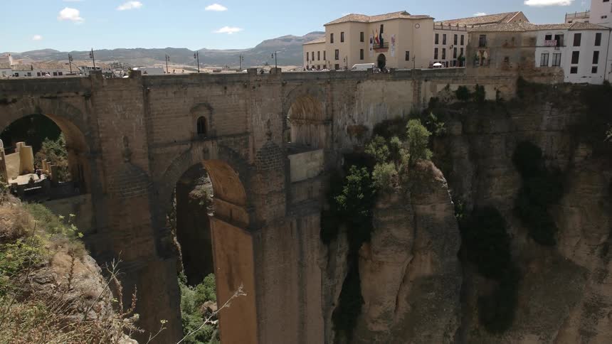 A large stone bridge leads to a town