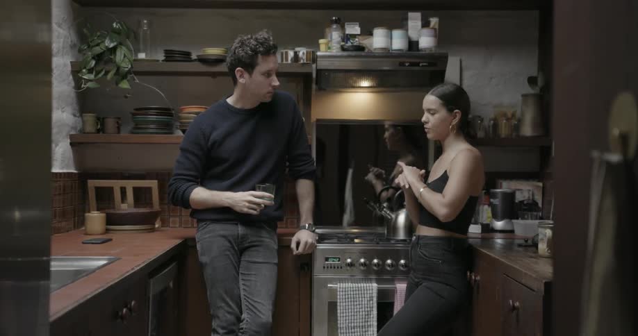 A man and woman talk together in the kitchen