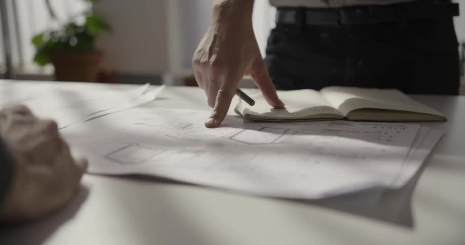 People look at blueprints on the table
