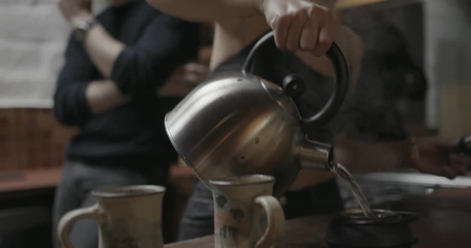 A woman is making tea on a counter