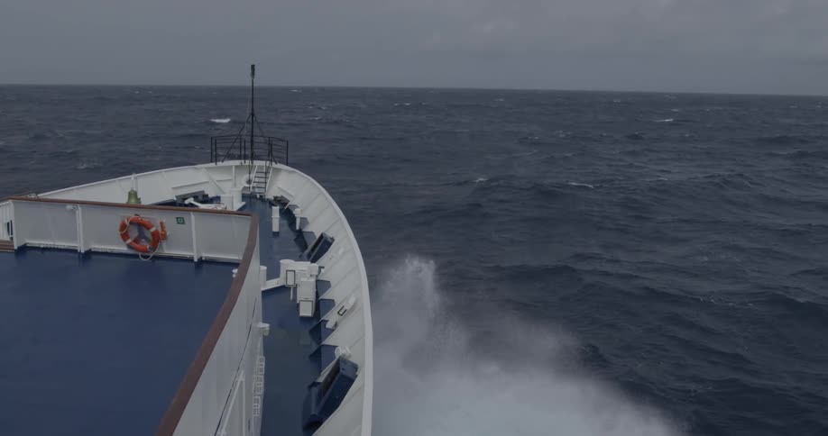 A ship is traveling in a rough moody ocean