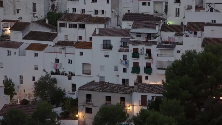 A block of white buildings are being filmed from a short distance away