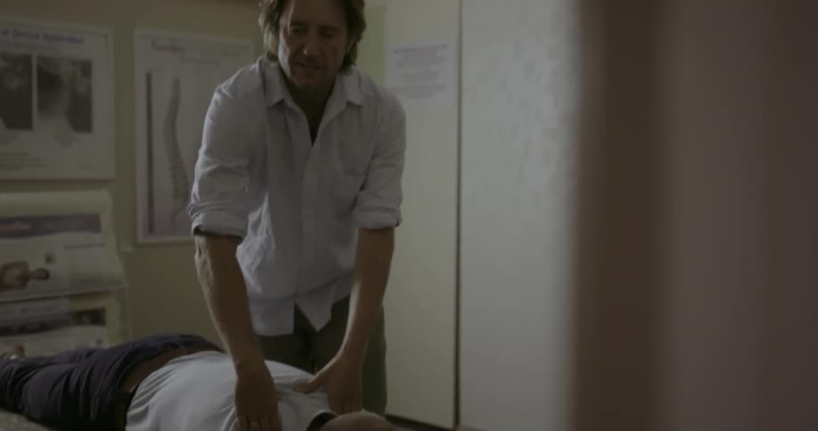 Doctor adjusts a patient's shoulders and back