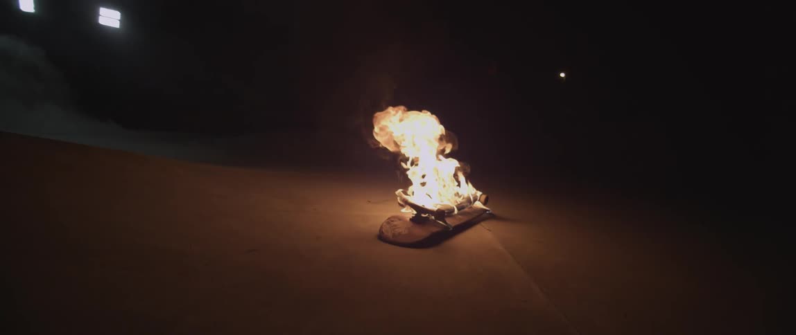 Skateboard lit on fire at night