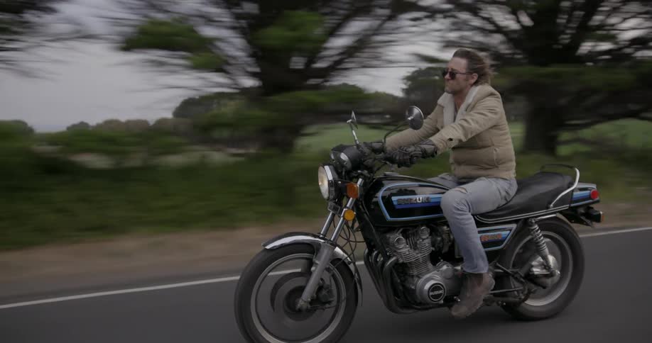 Man riding a motorcycle down a road