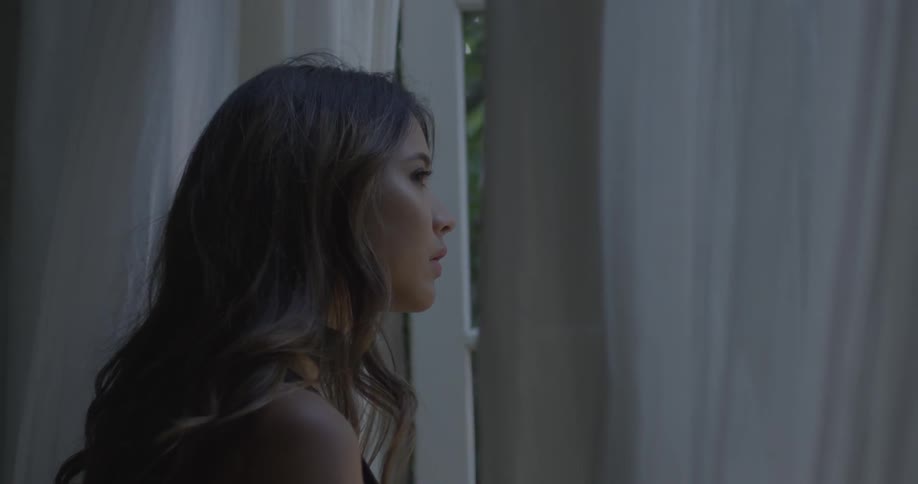 A woman is gazing through a open window