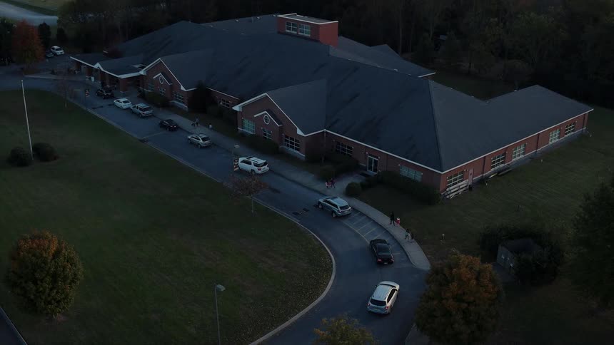 Cars pulling up to a large building