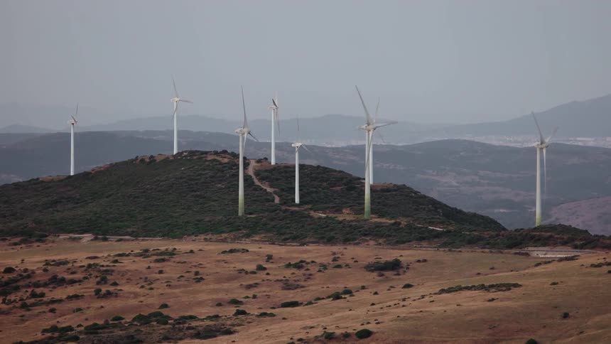 The hills ahead are covered with windmills