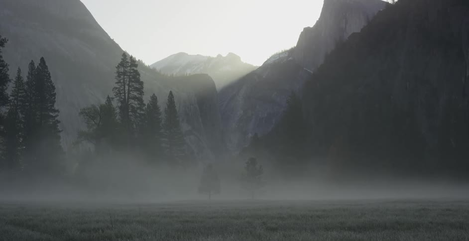 The field before the mountain is covered in fog
