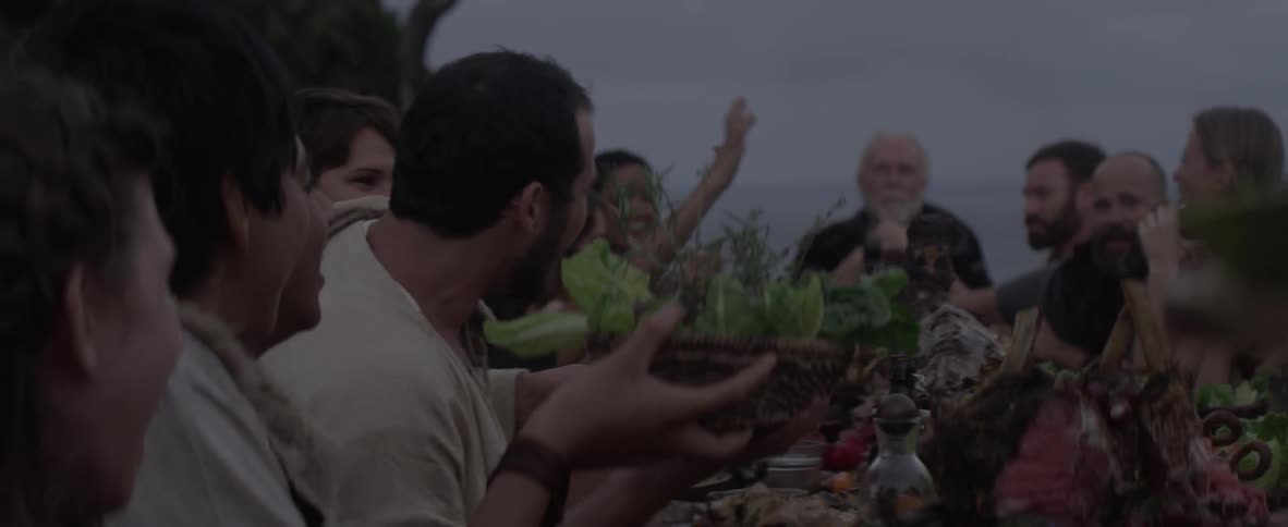 A family eat at a table outdoors