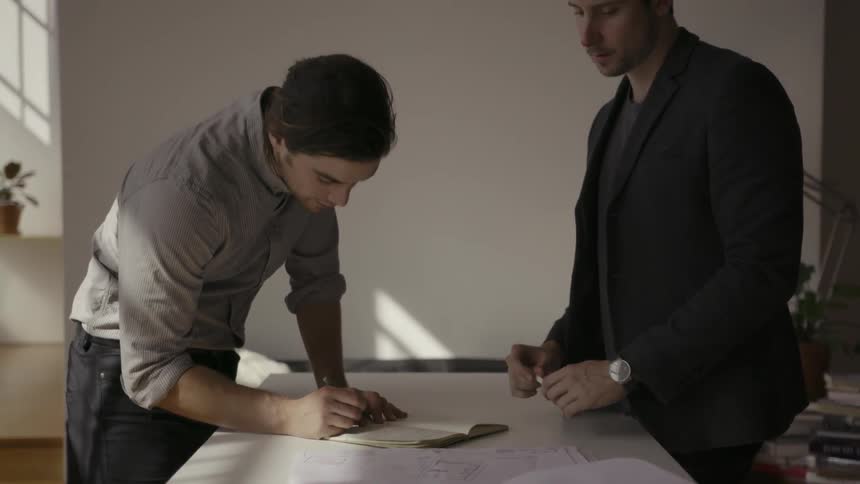 A man having a discussion with another man and marking something down