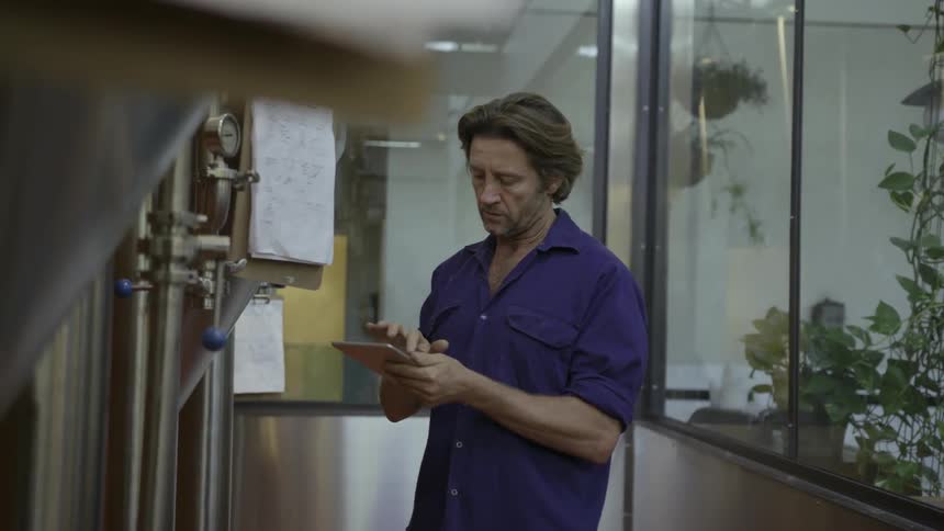 A man walks over to a clipboard to check it