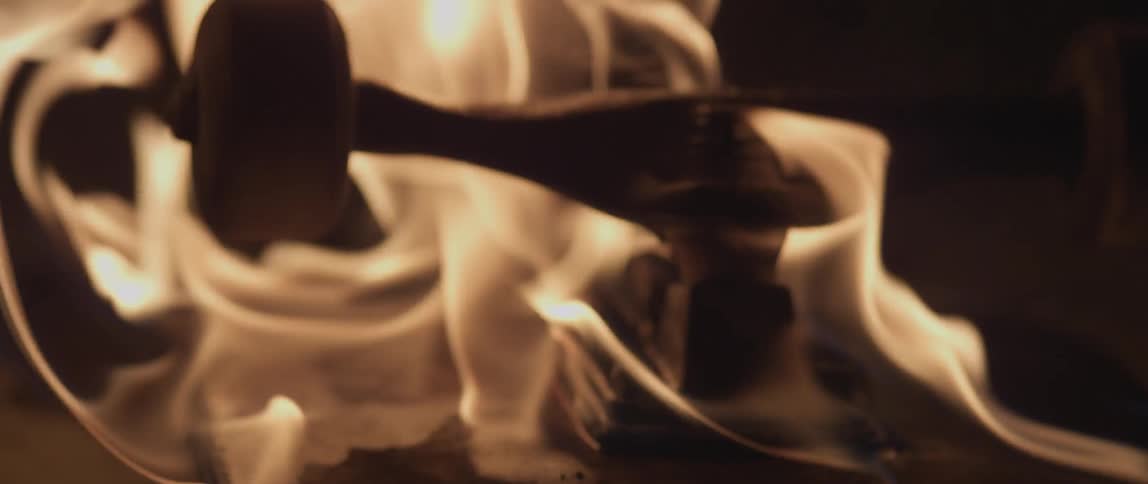 A skateboard is upside down and on fire