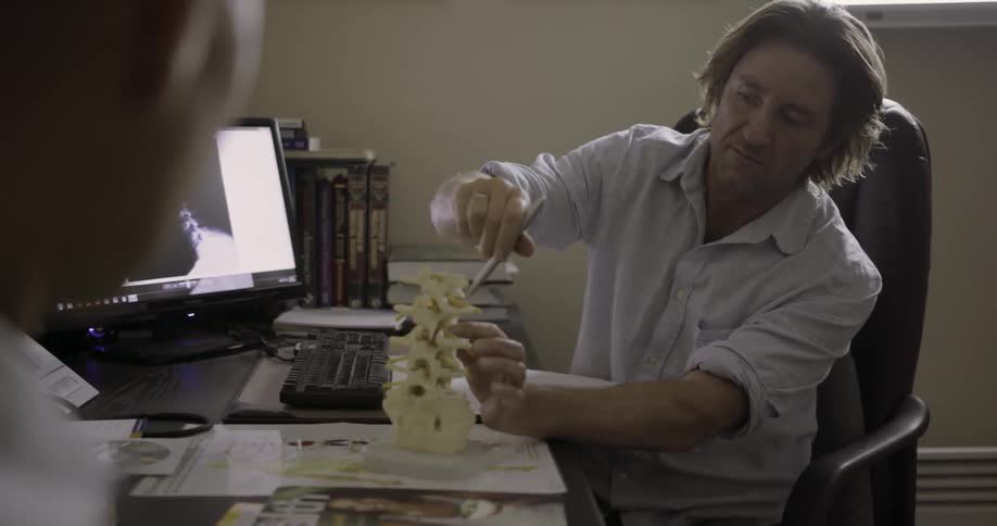 A man is pointing out parts of the neck to another person