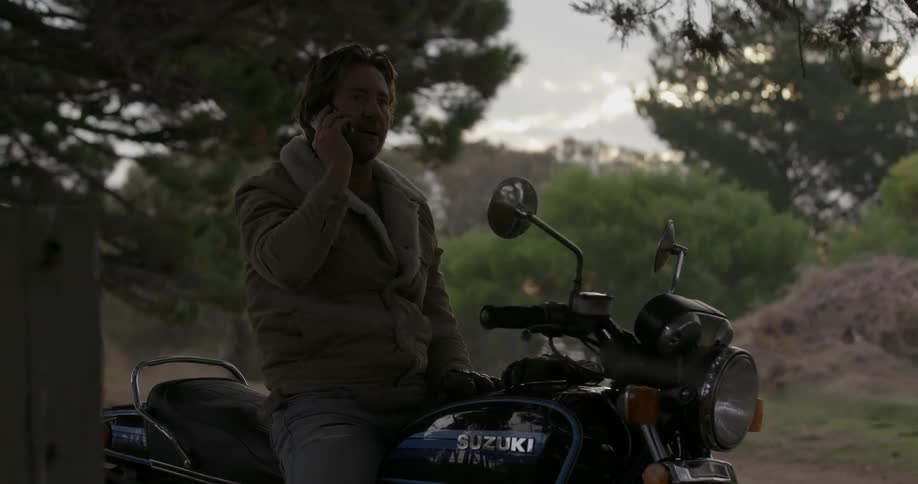 A man talking on the phone while sitting on a motorcycle