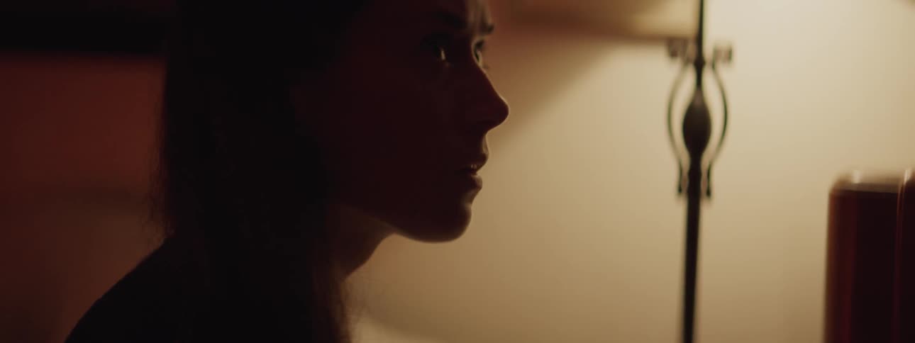 A woman  talks in a dark room