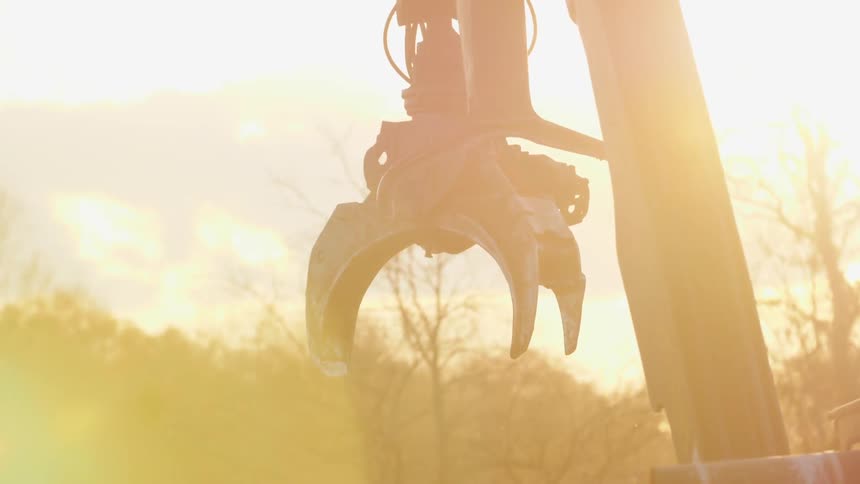 Metal crane moves backwards in the sunlight