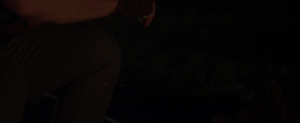 A man is picking up an instrument in the dark