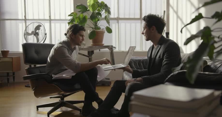 Two men are discussing business in an office
