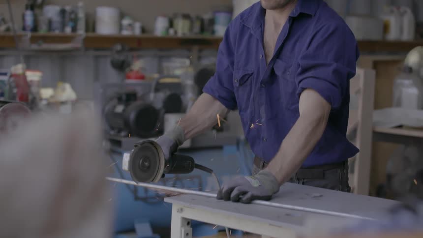 A man is cutting a pipe in his shop