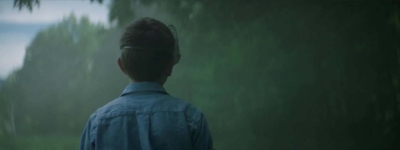 A boy wearing a mask is walking by the forest